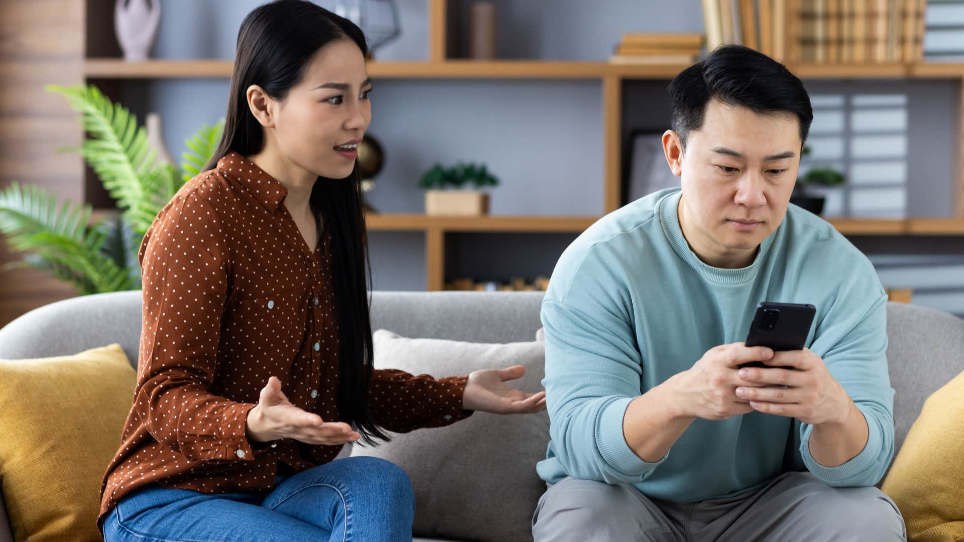 man who's always on his phone sitting by his annoyed wife