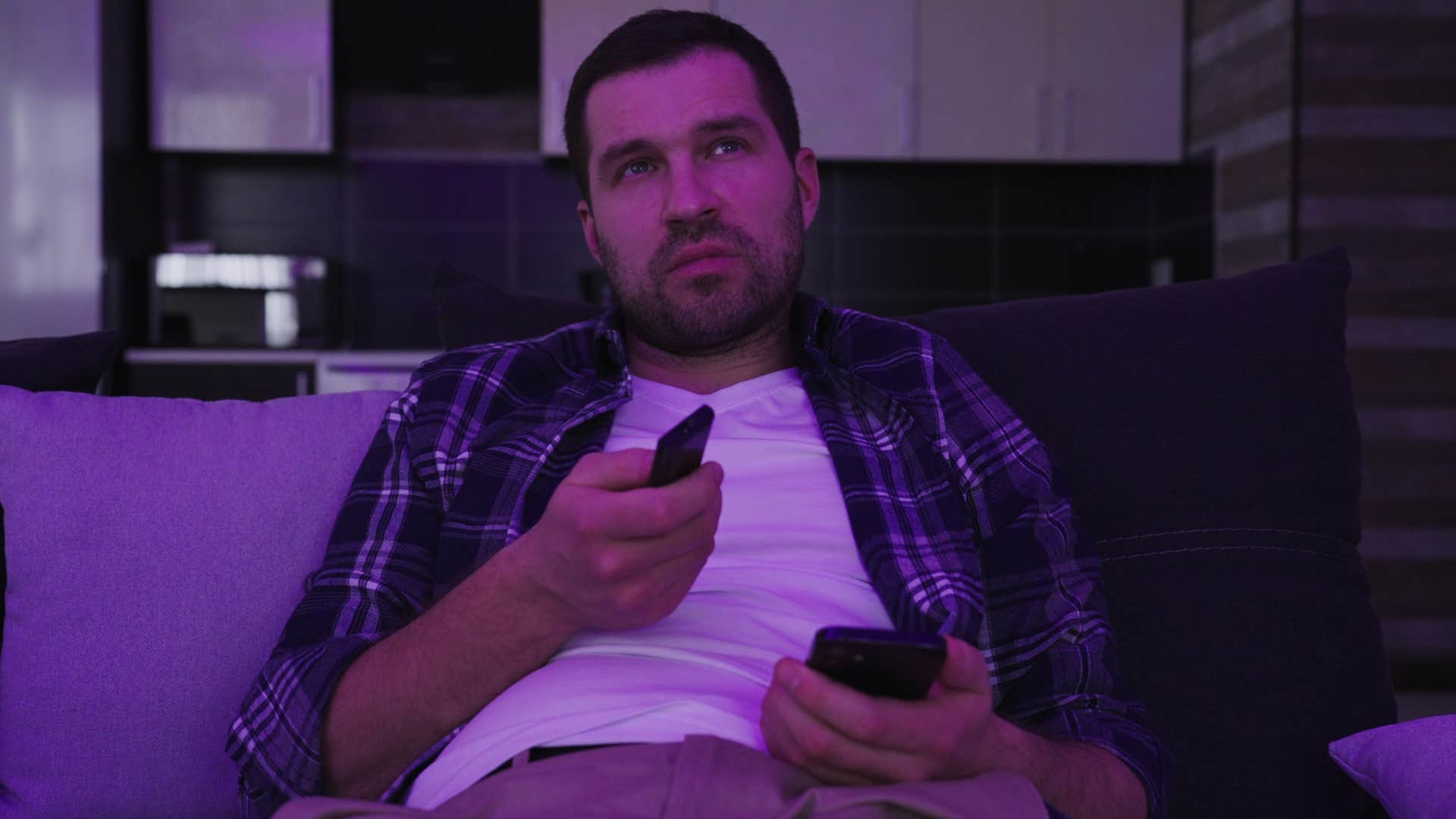 man watching tv alone not making time to cuddle partner before bed