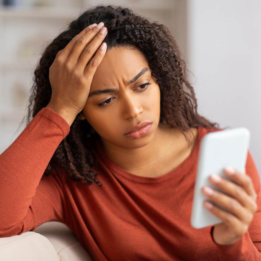 upset woman looking at phone because man vanished after third date because he thinks they're incompatible