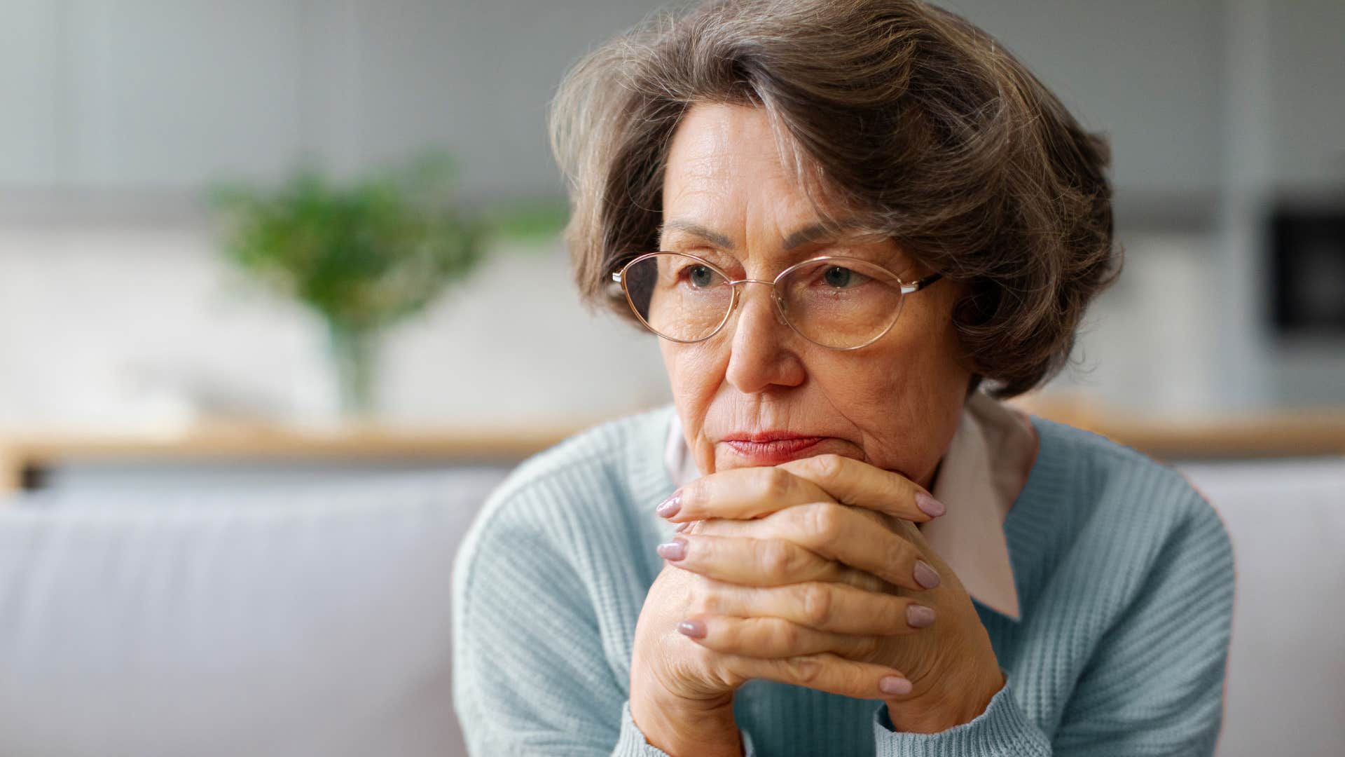 emotionally exhausted woman sitting quietly at home