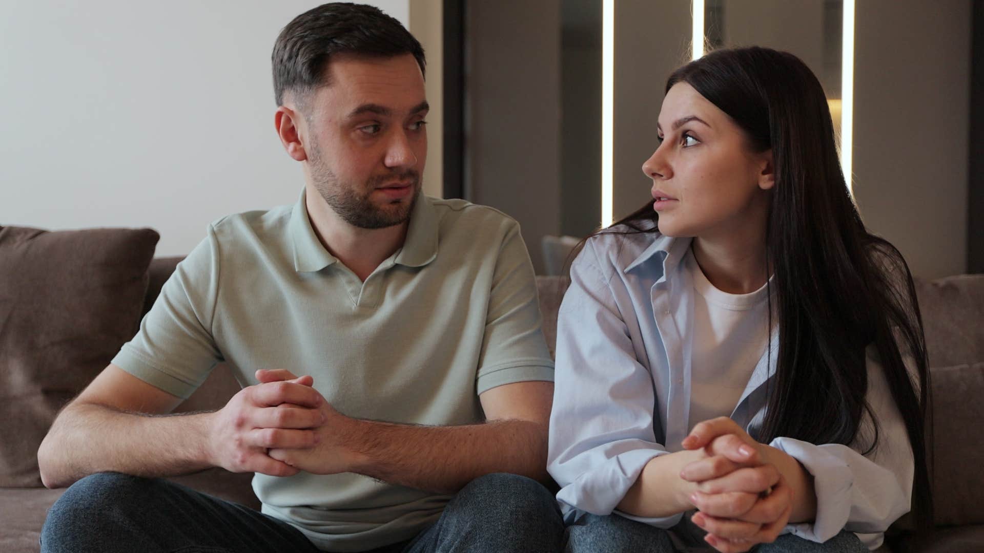 unhappy woman telling concerned partner she's fine