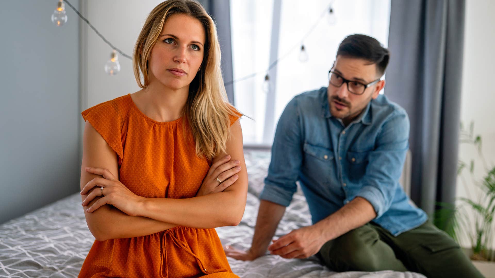 couple sitting on bed woman saying im not in the mood