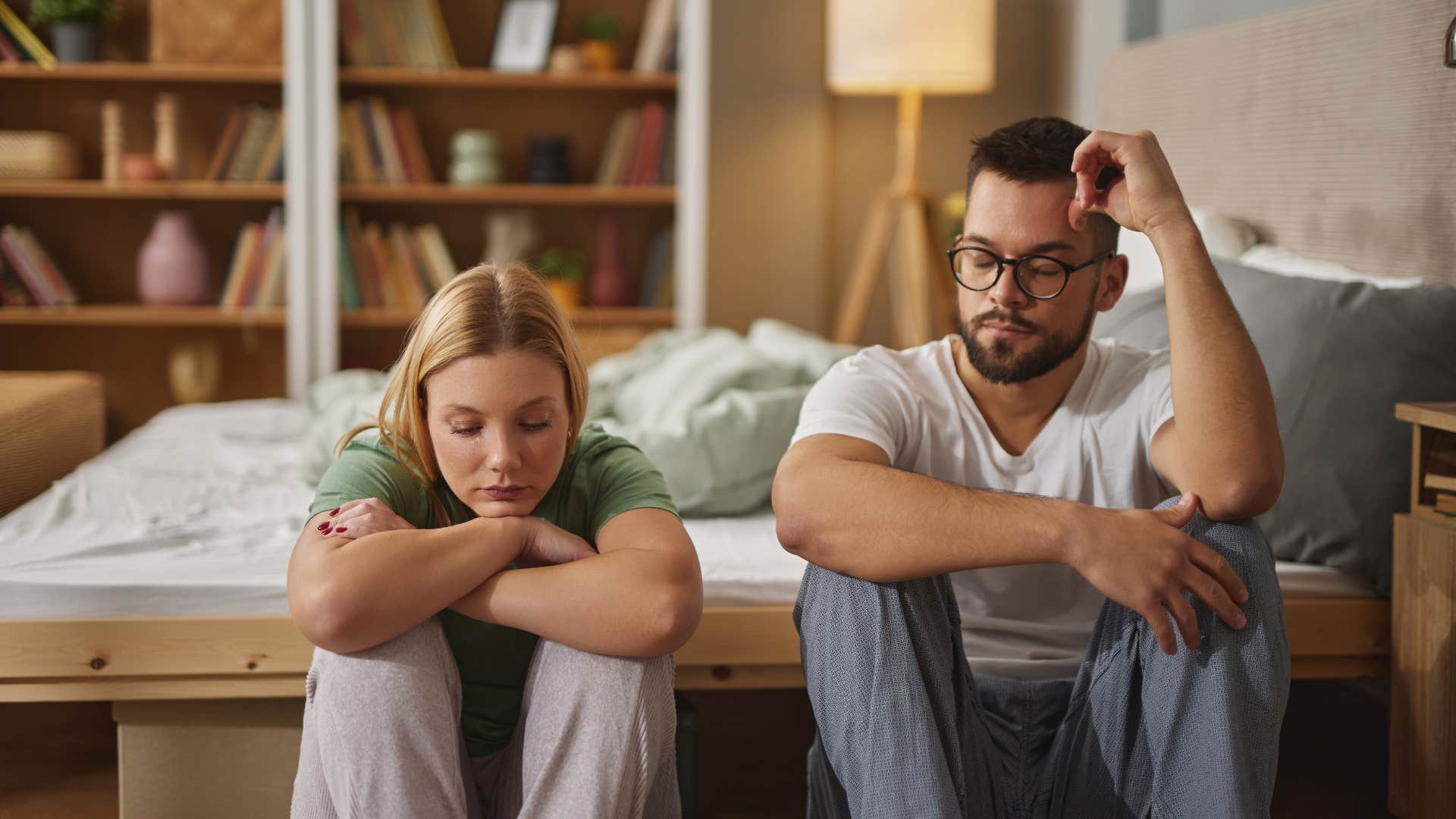 unhappy couple during argument sitting on floor 