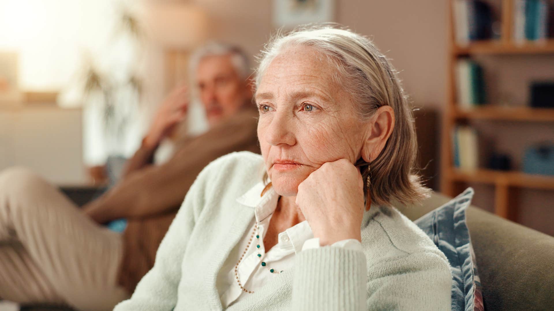 wife thinking while sitting away from husband on couch