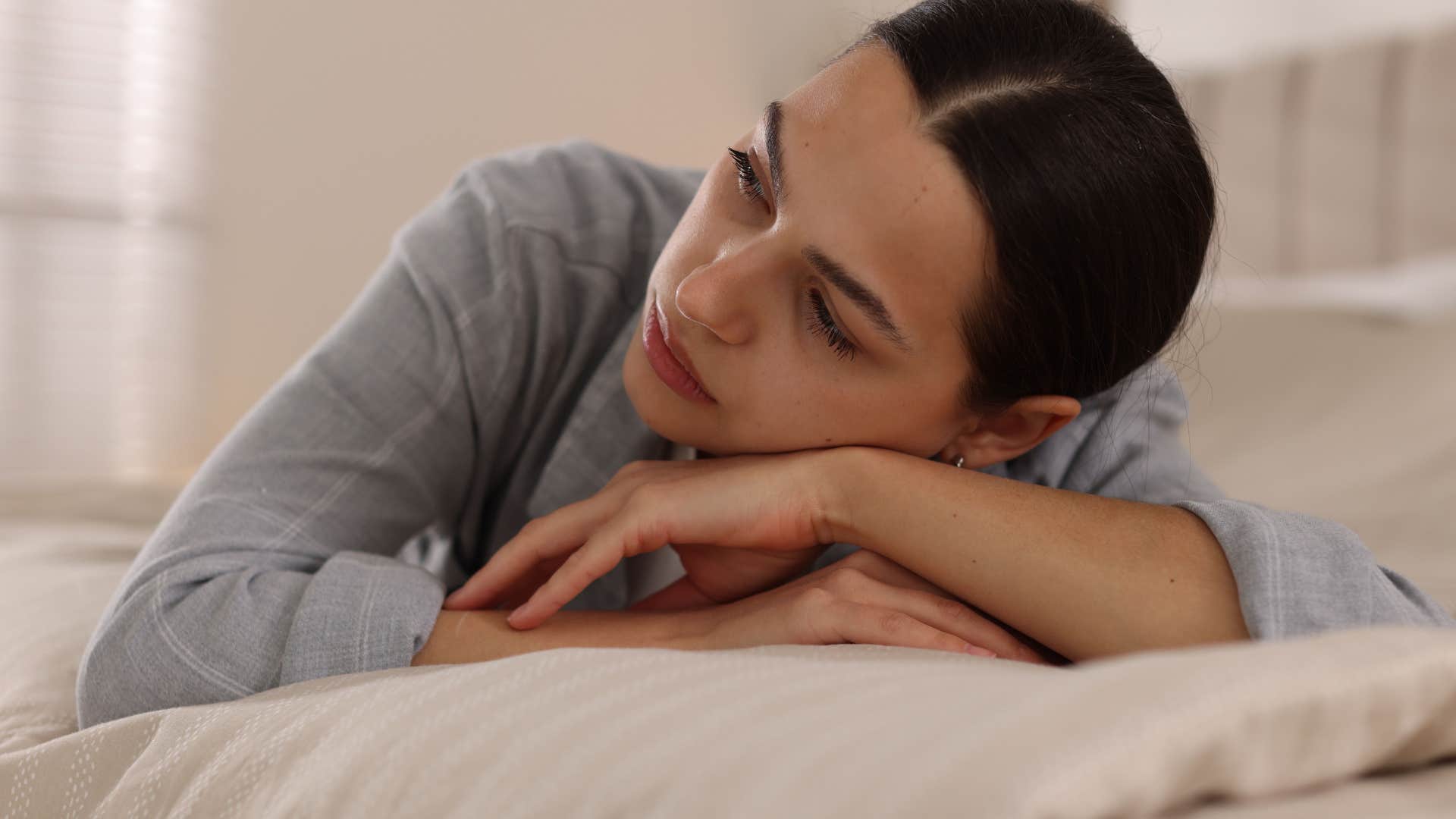depressed woman lying in bed