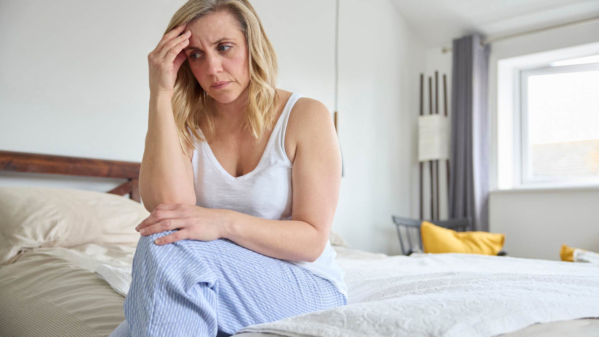 insecure woman sitting on the edge of the bed
