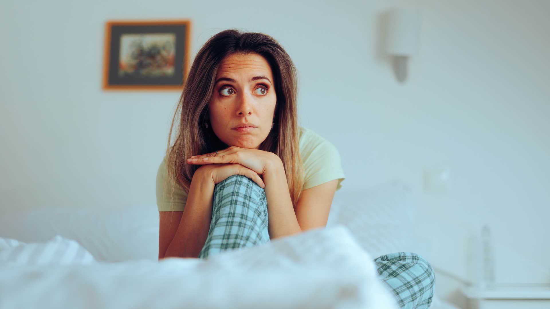 upset woman sitting up in bed 