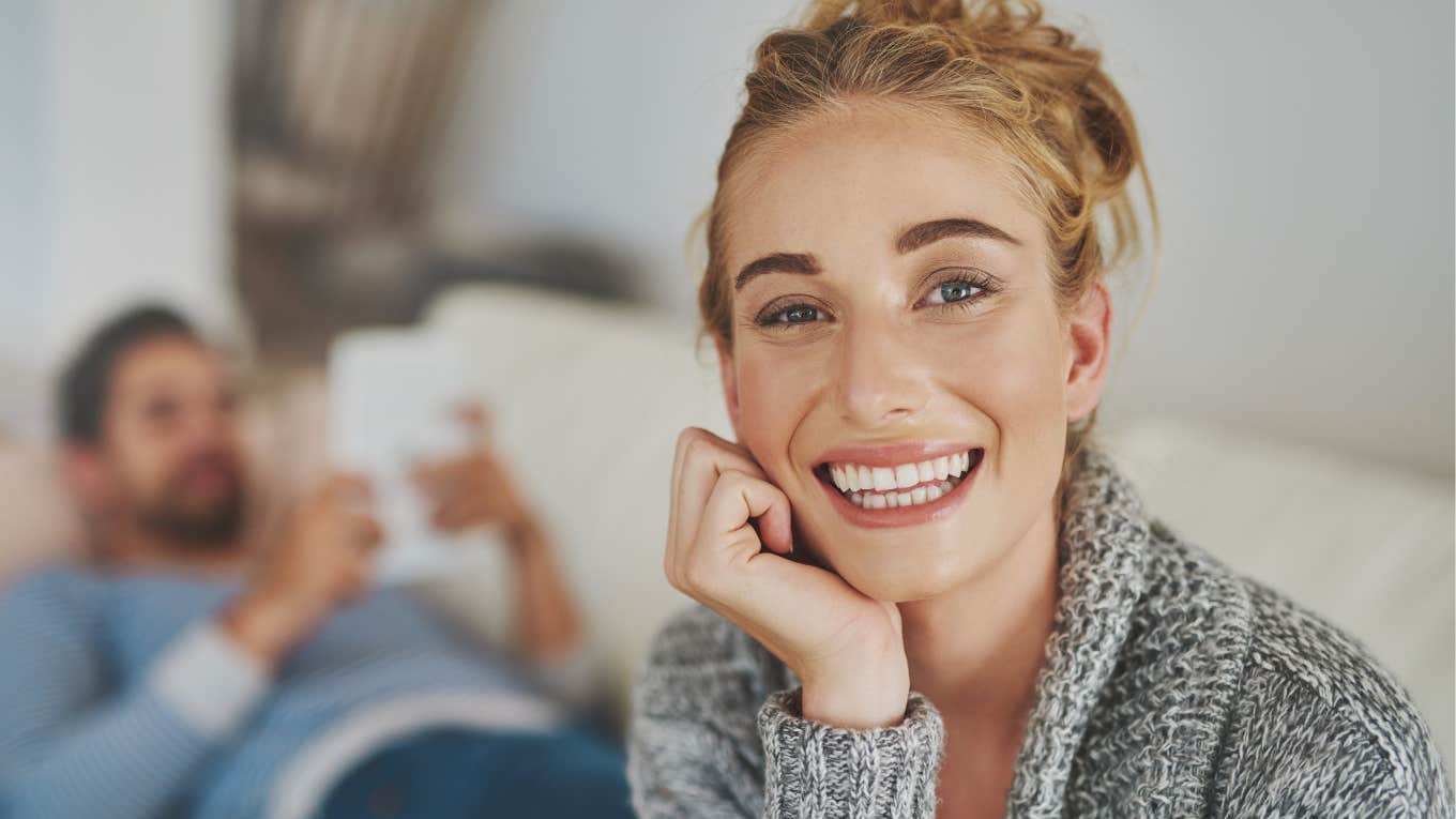 fed up woman forcing a smile in unhappy relationship