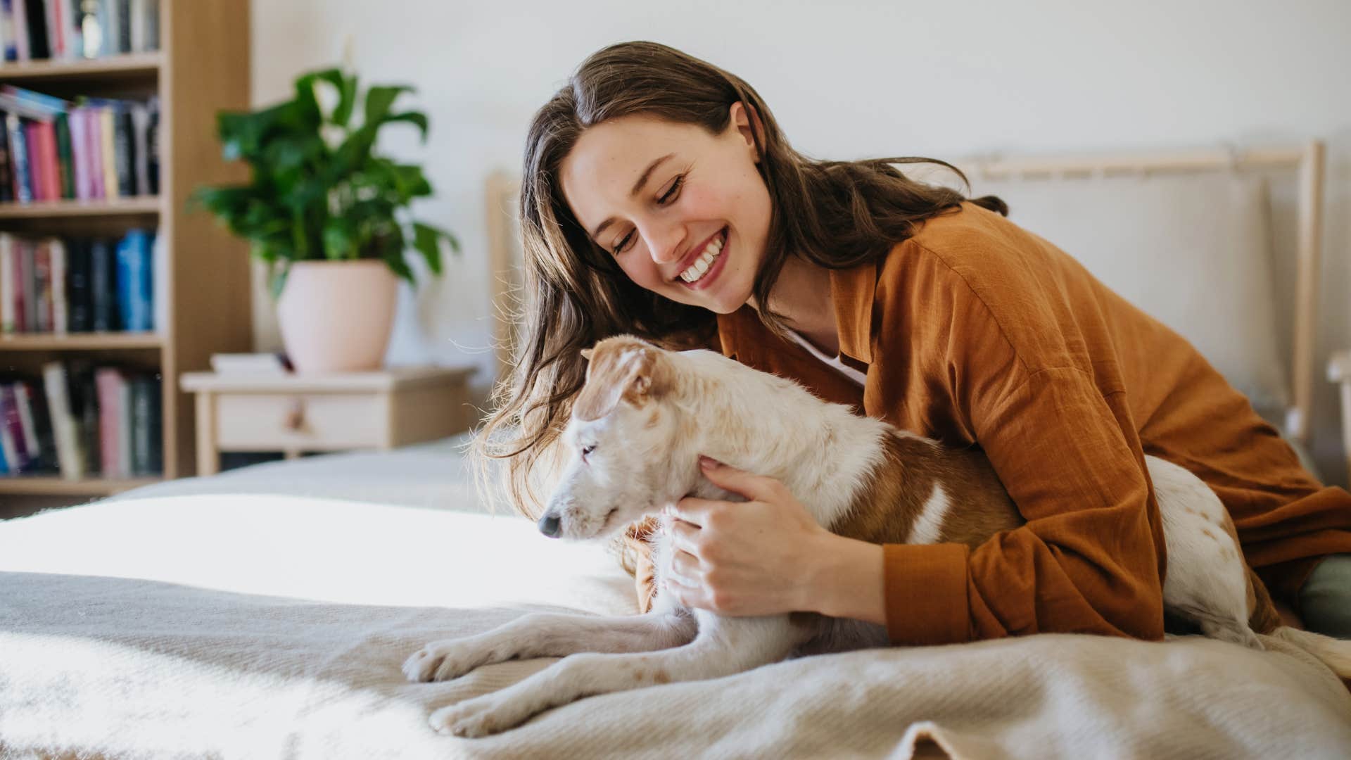 woman with a bedroom that's a safe space smiling with her dog