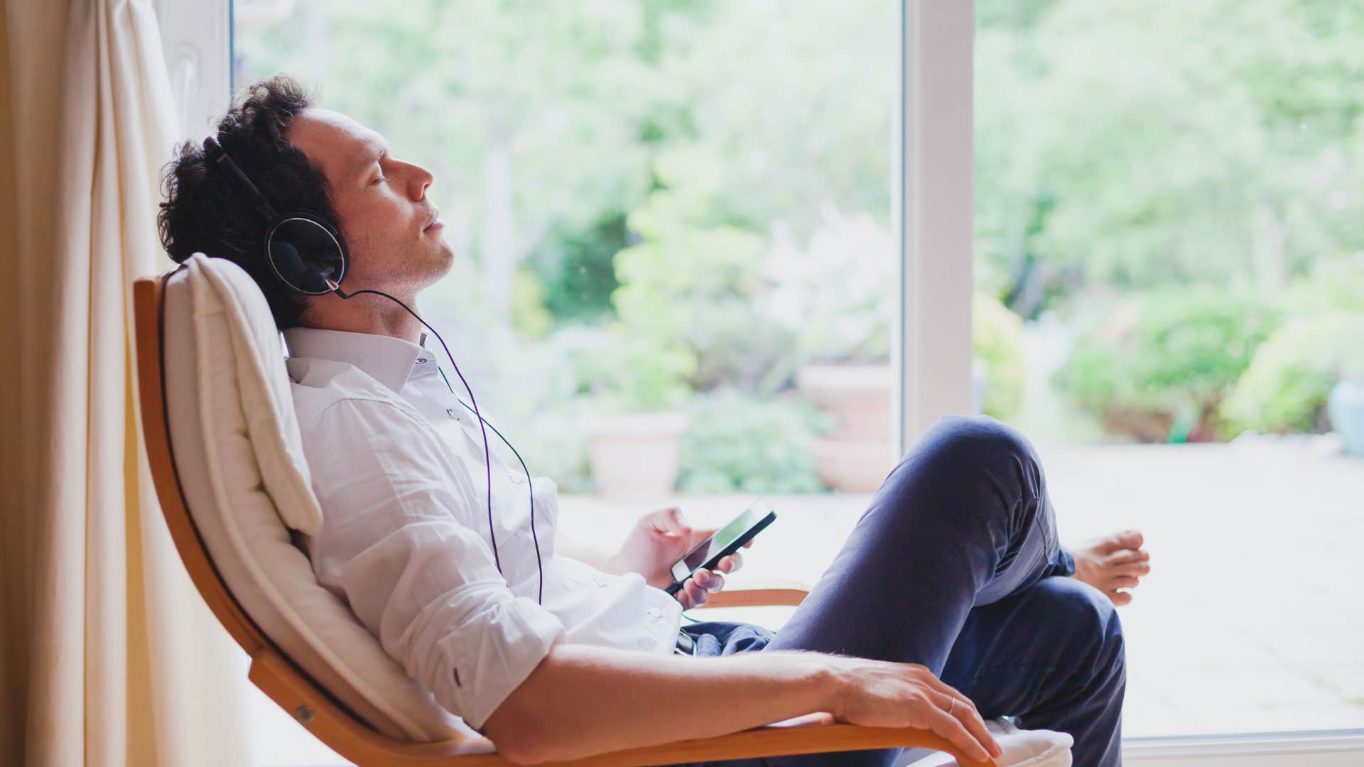 man relaxing listening to music at home