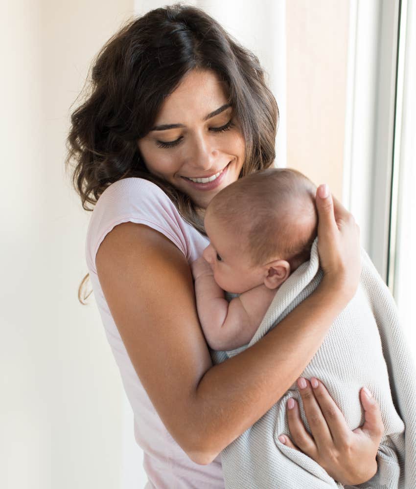 happy woman holding newborn baby