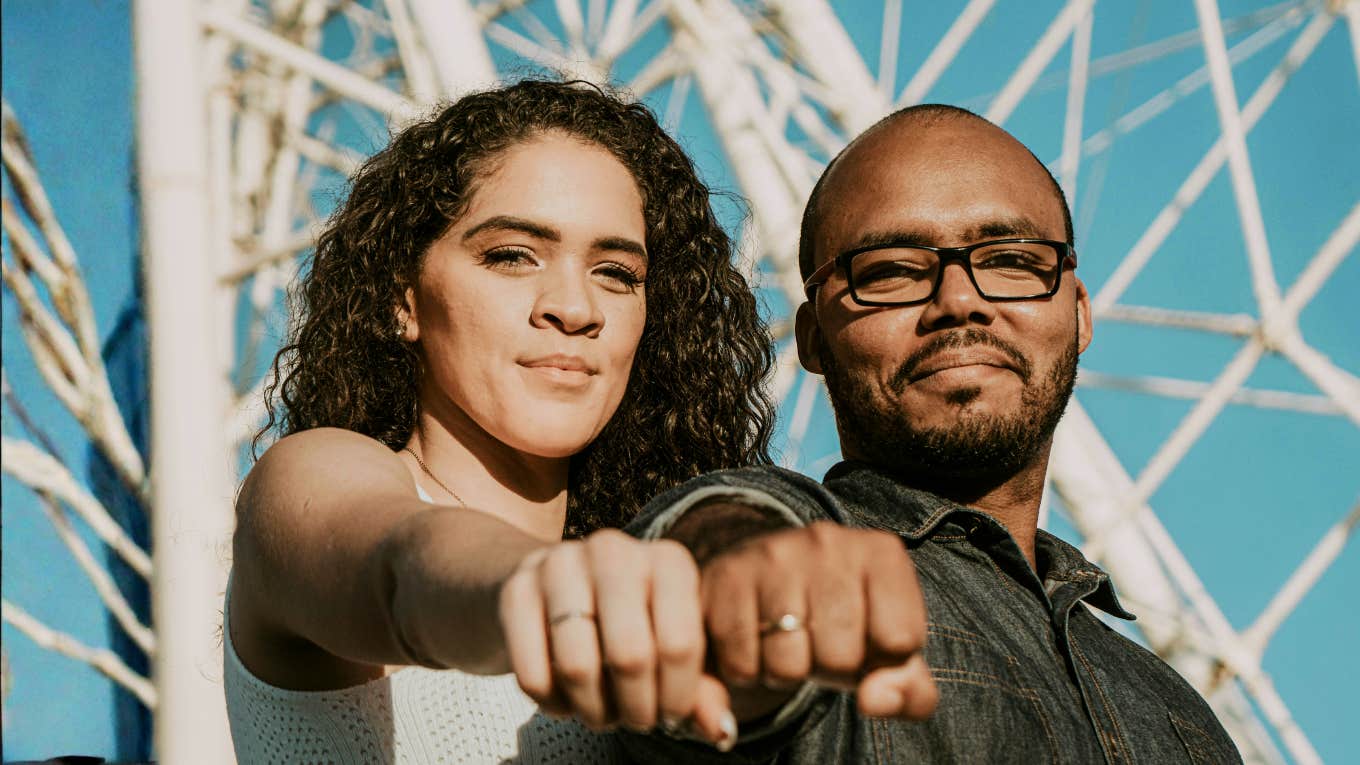 confident driven couple standing side by side with fists forward, symbolizing the simple signs you’ve found a high-achieving soulmate and are truly a power couple