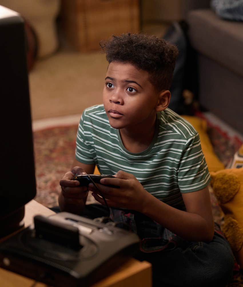 Focused boy plays retro video game showing self-sufficiency life skill