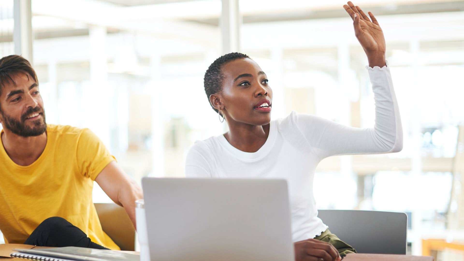 Curious person raises hand to ask question showing habit of visionaries 