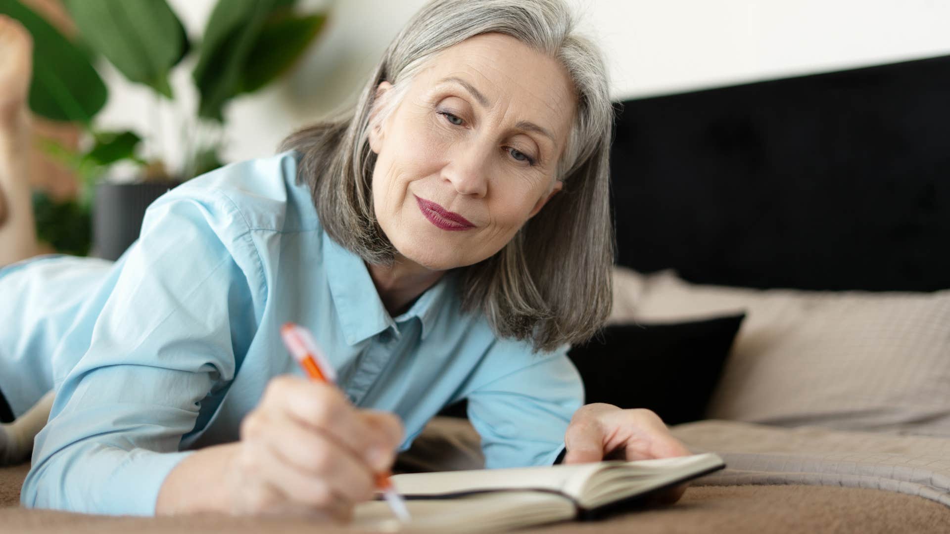 Happy person writes in notebook showing commitment to be unbothered