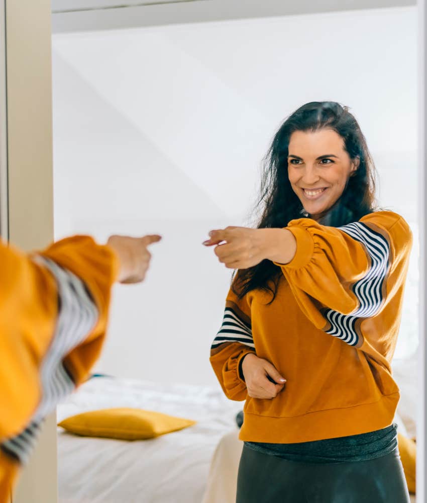 Confident person points at self in mirror showing change to be happier
