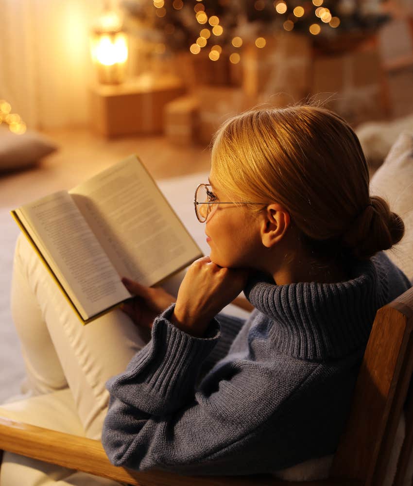 gen z woman reading book by christmas tree