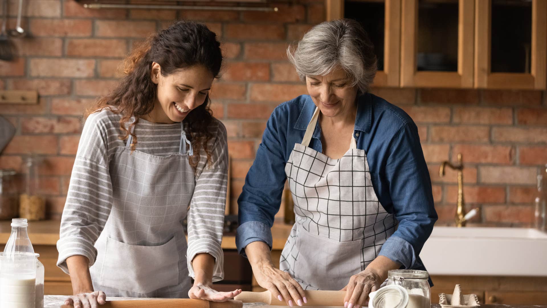 baby boomer mother teaching daughter how to cook from scratch