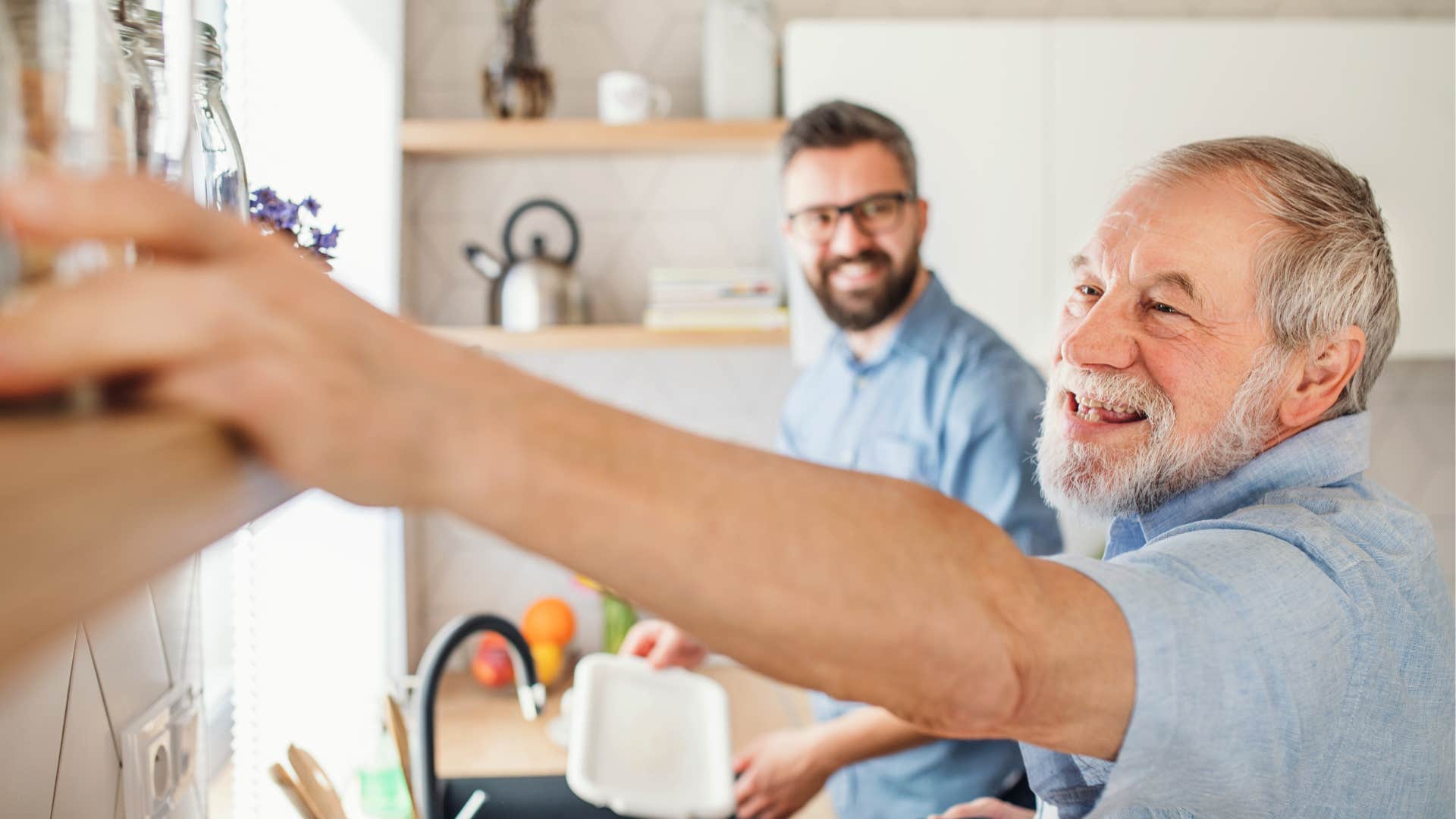 son helping boomer father wash dishes together