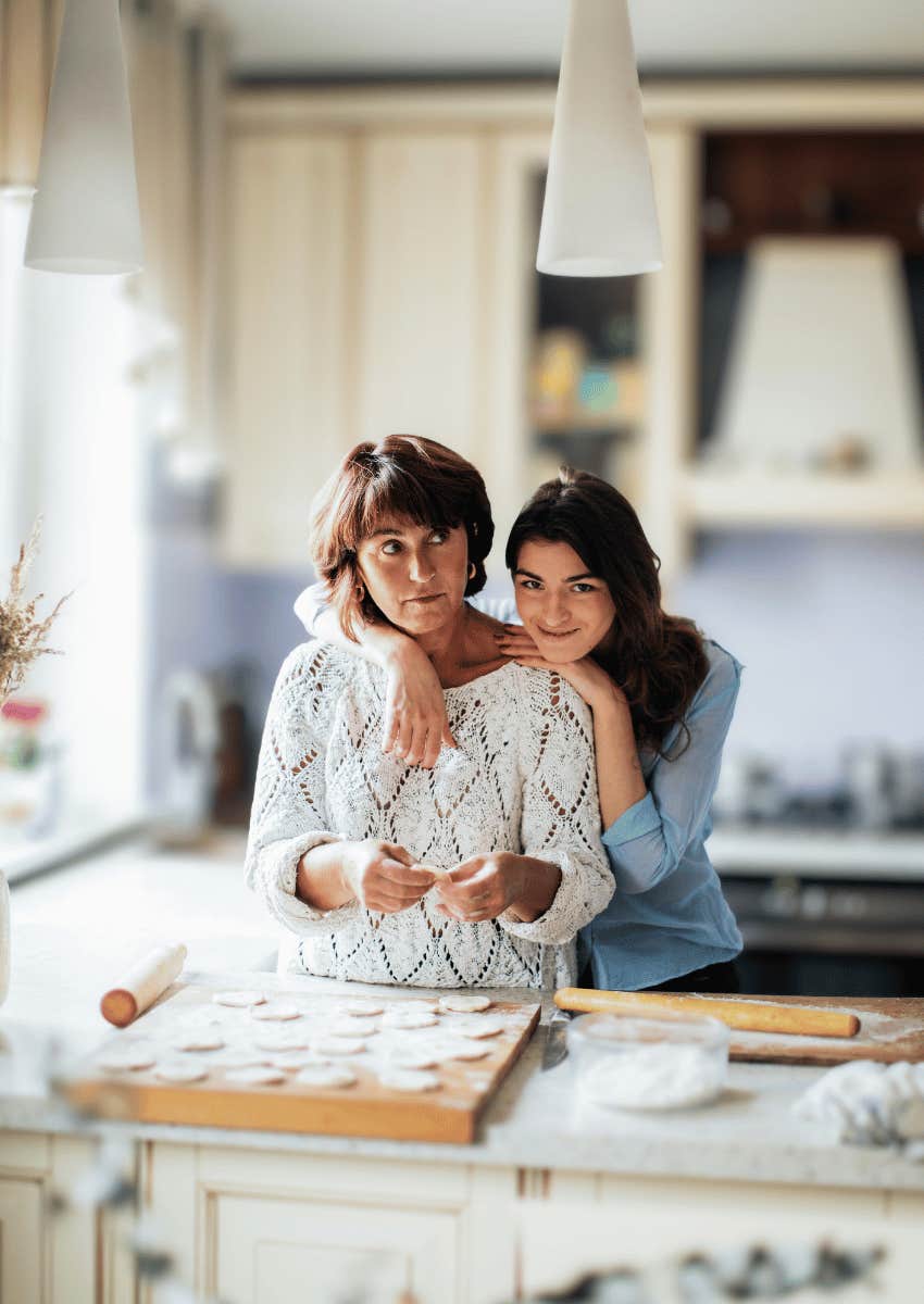 confident daughter hugging mom in the kitchen