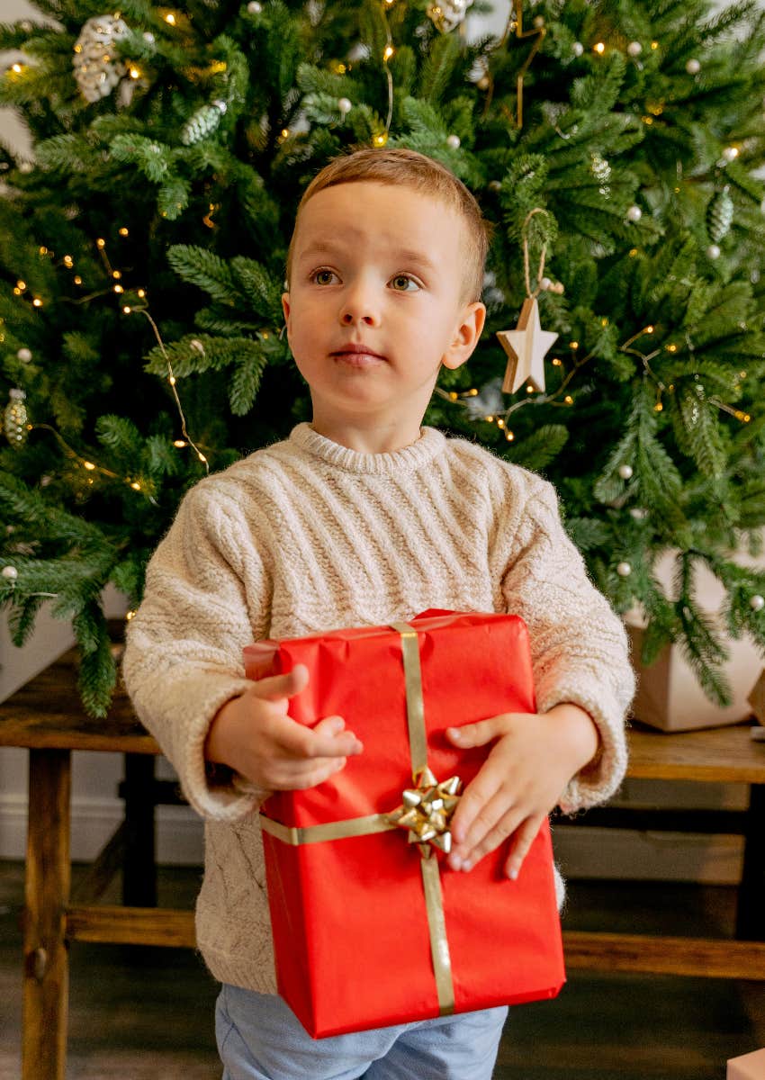 little boy holding a Christmas gift