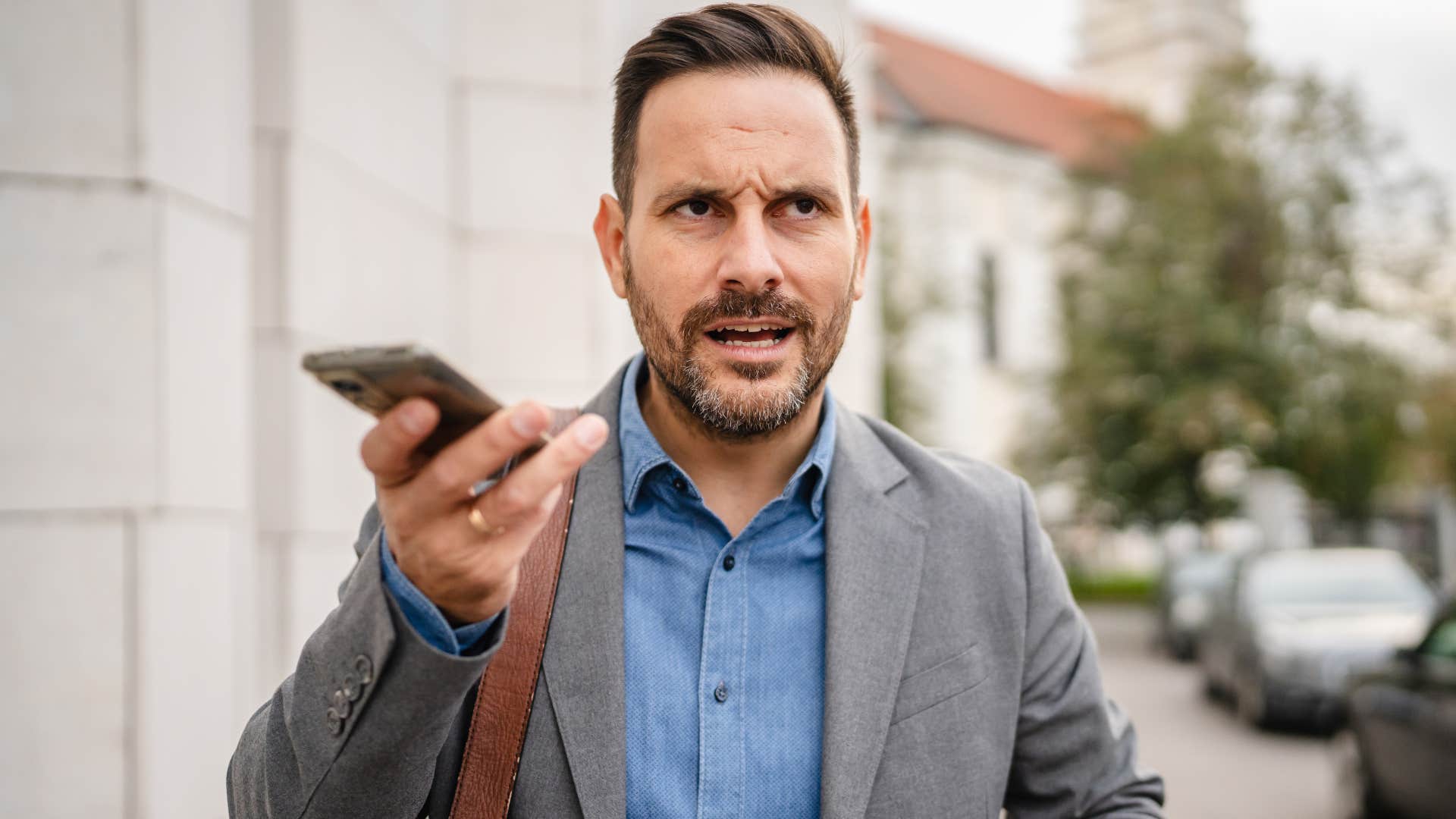 Man talking loudly on the phone outside.