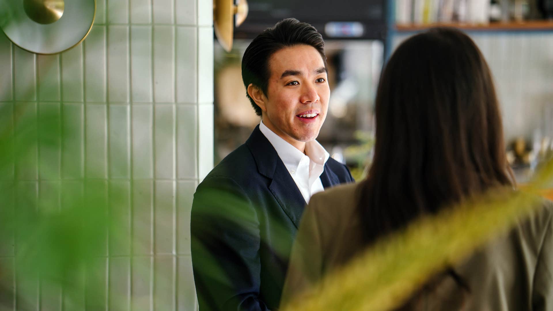 well-dressed man name-dropping to colleague