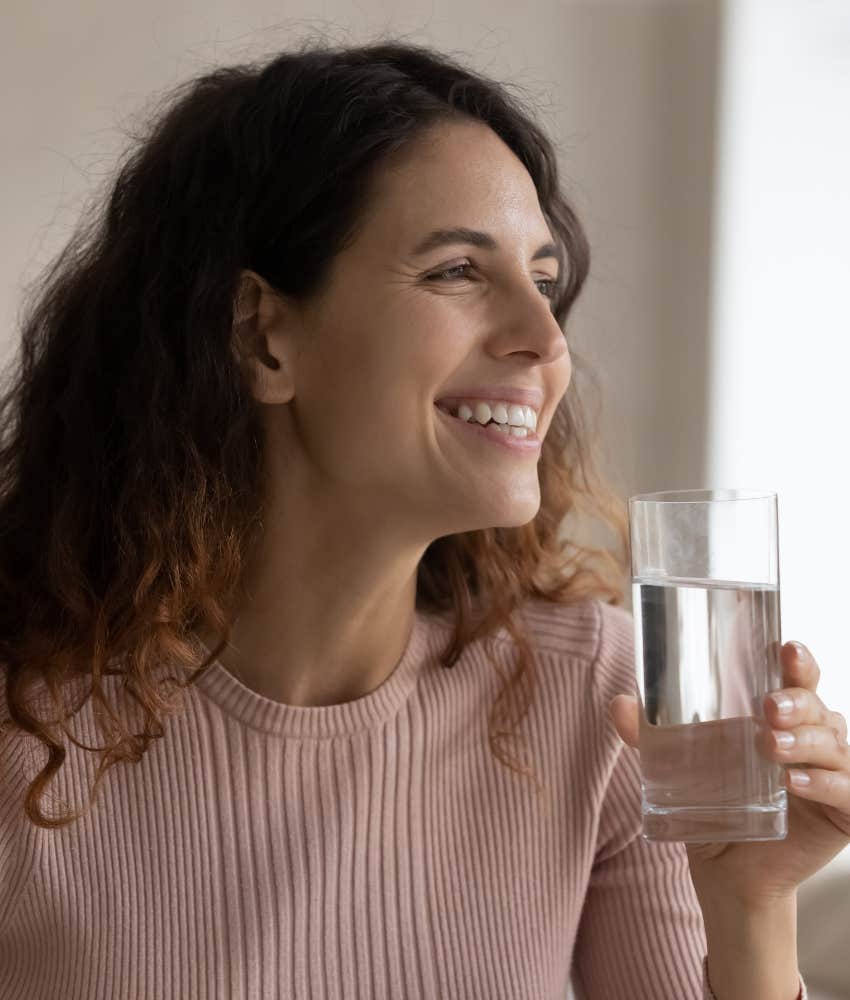 Happy person drinks water showing empowerment through self love