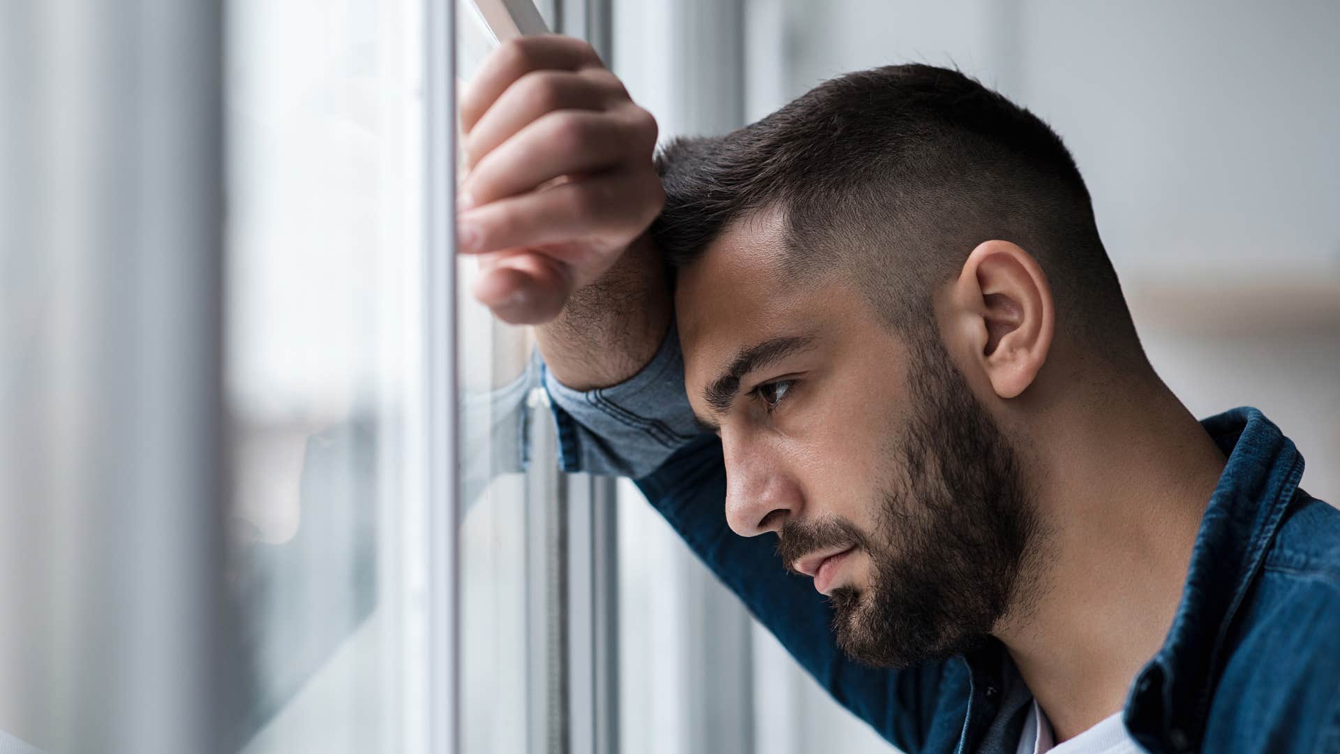 man leaning on window avoiding challenges