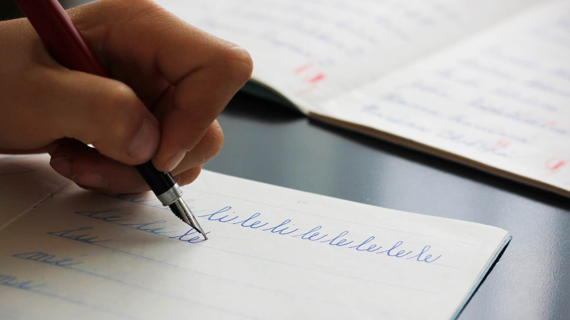person writing in cursive on paper