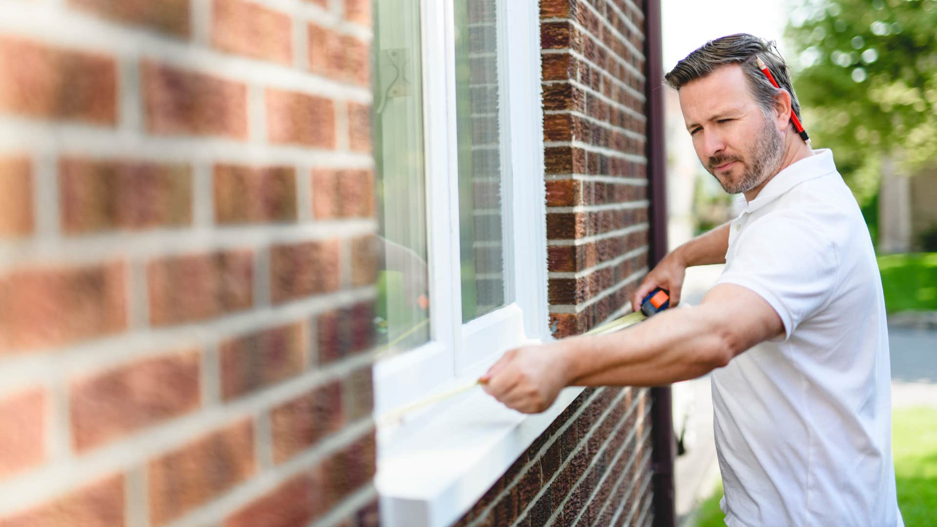 man measuring window to help with home repairs
