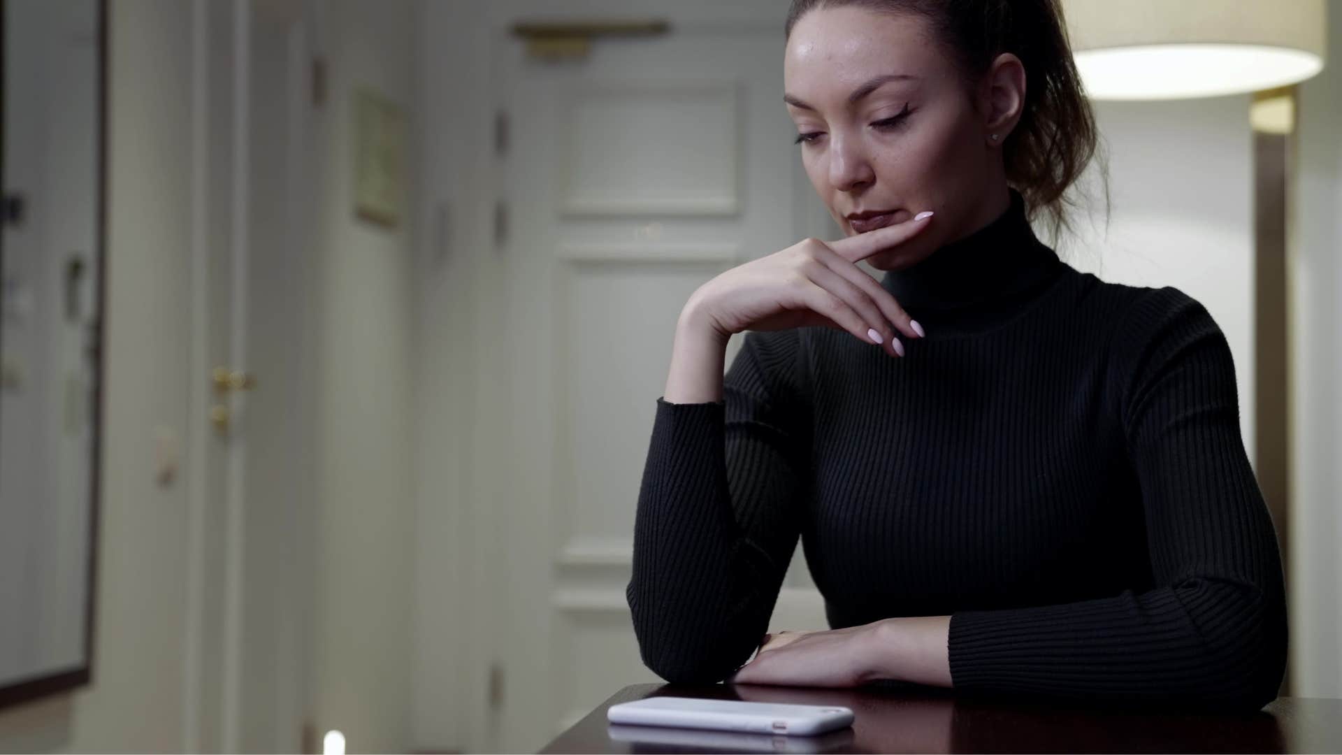 woman who is infatuated as she sits by phone waiting for a call