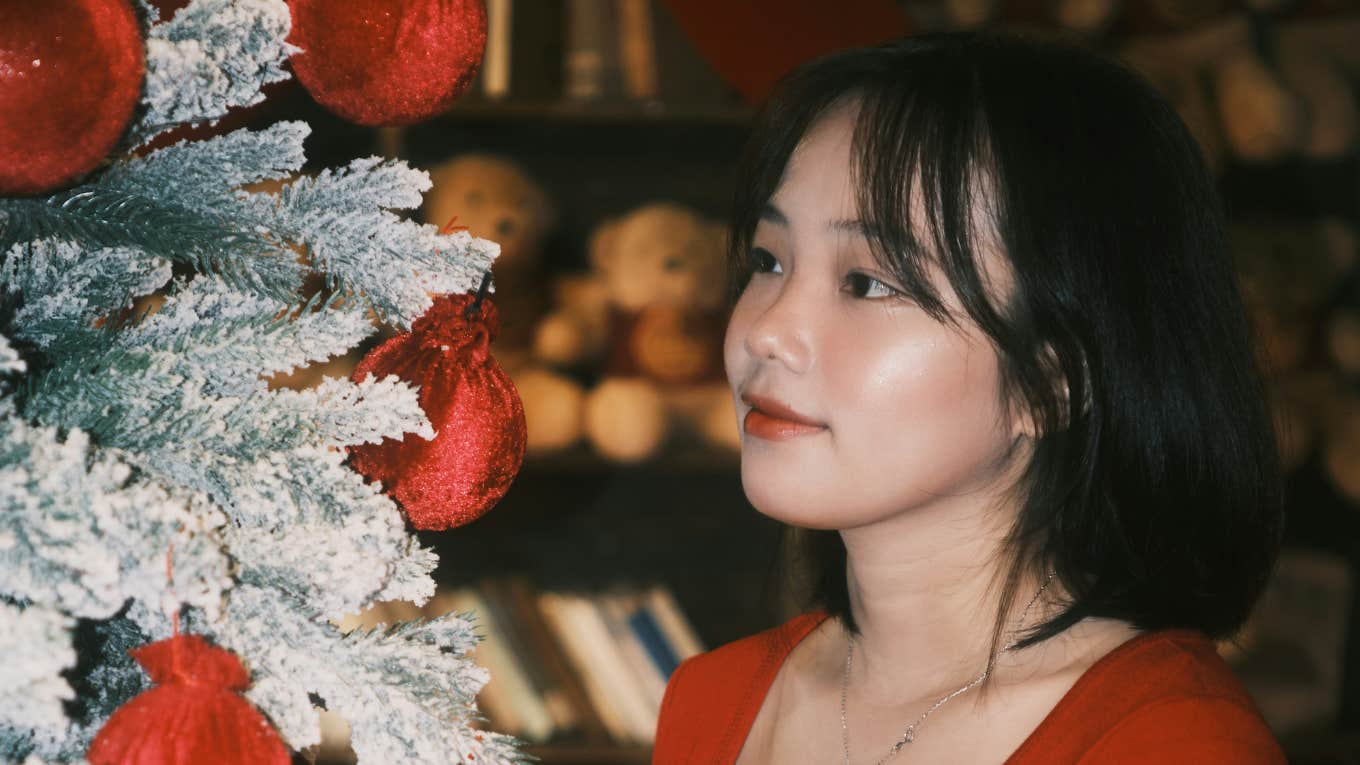 Woman puts up holiday decor.