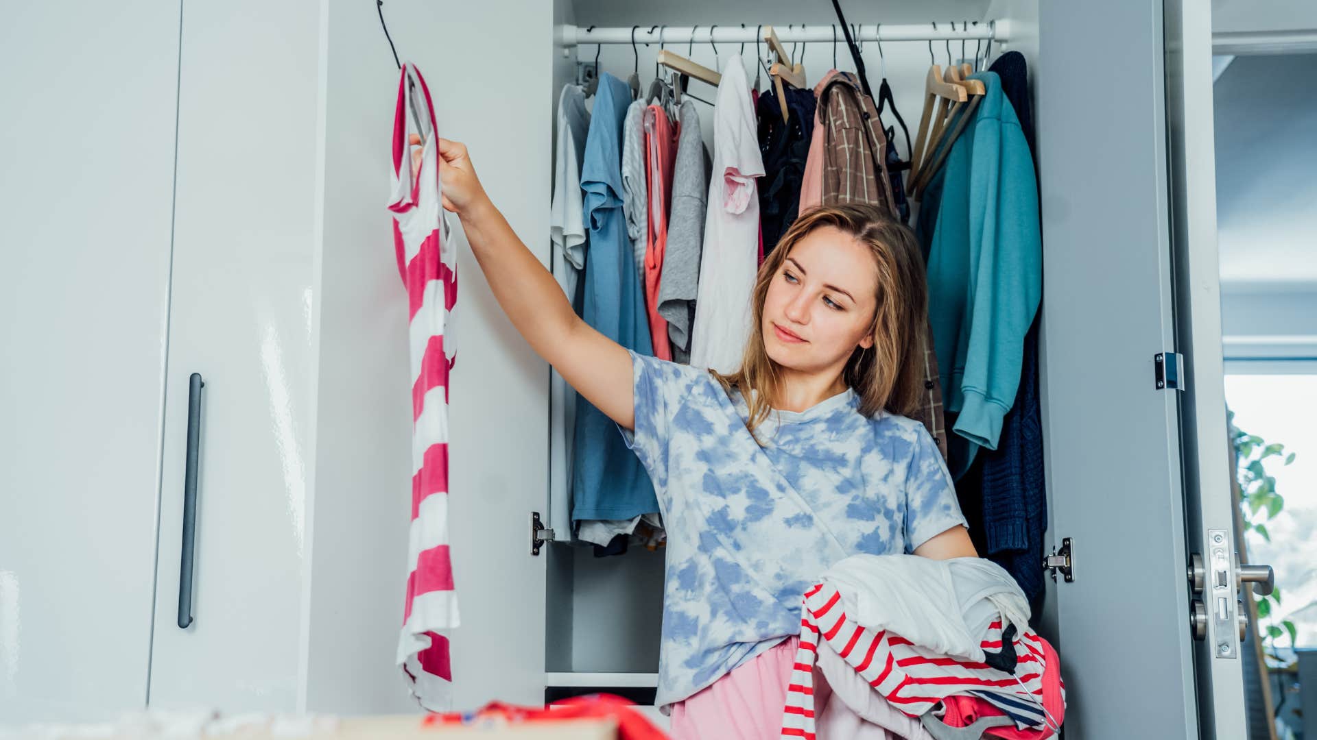woman looking through her closet of hand-me-downs