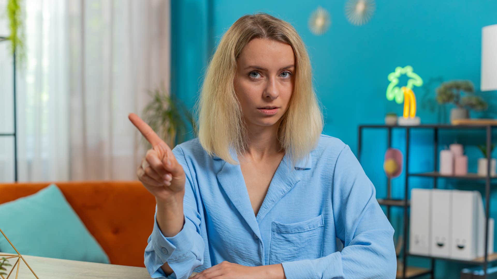 young woman waving her finger saying no