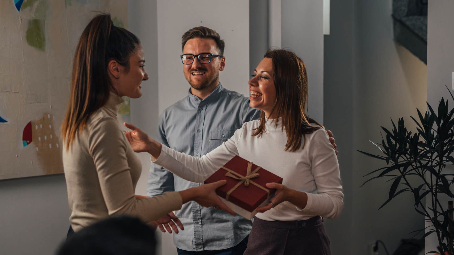 gracious party host giving guest a gift