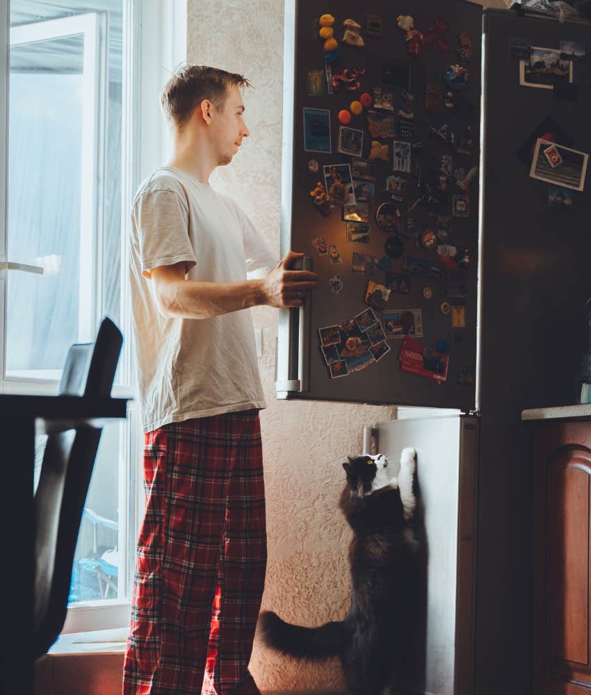 Man taking inventory in his fridge and realizing he has more food than he thought