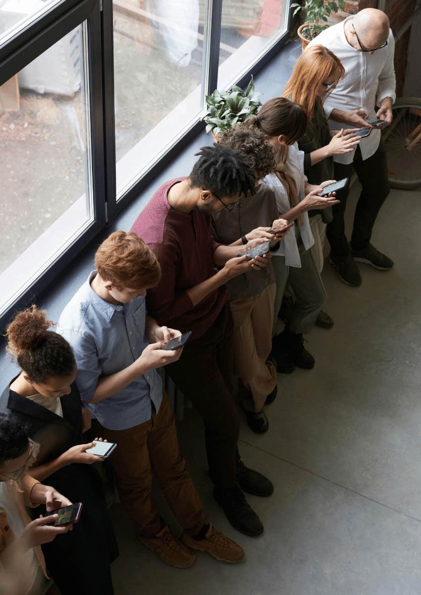 group of people near each other with their eyes on their phone screens