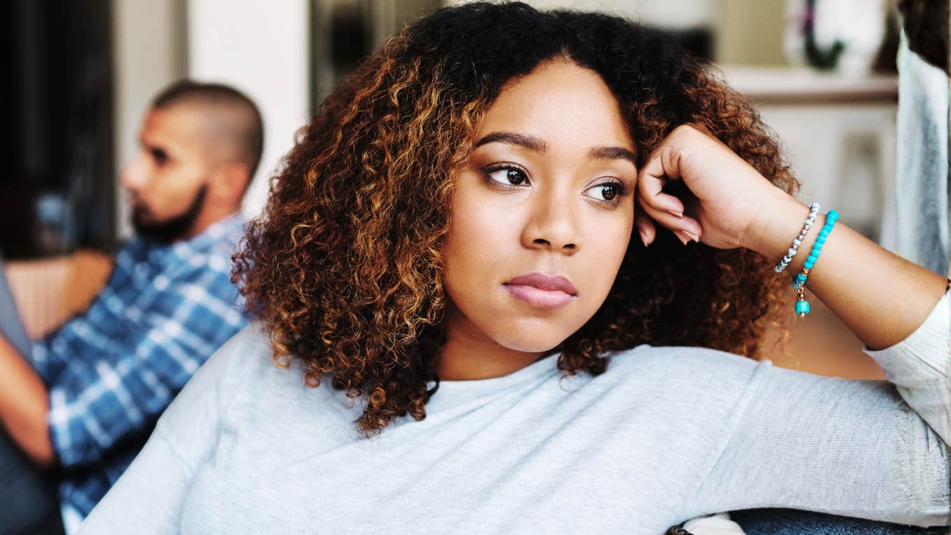 Worried woman sitting apart from her partner showing the habits you need to say goodbye to in your thirties and forties for a happy marriage.