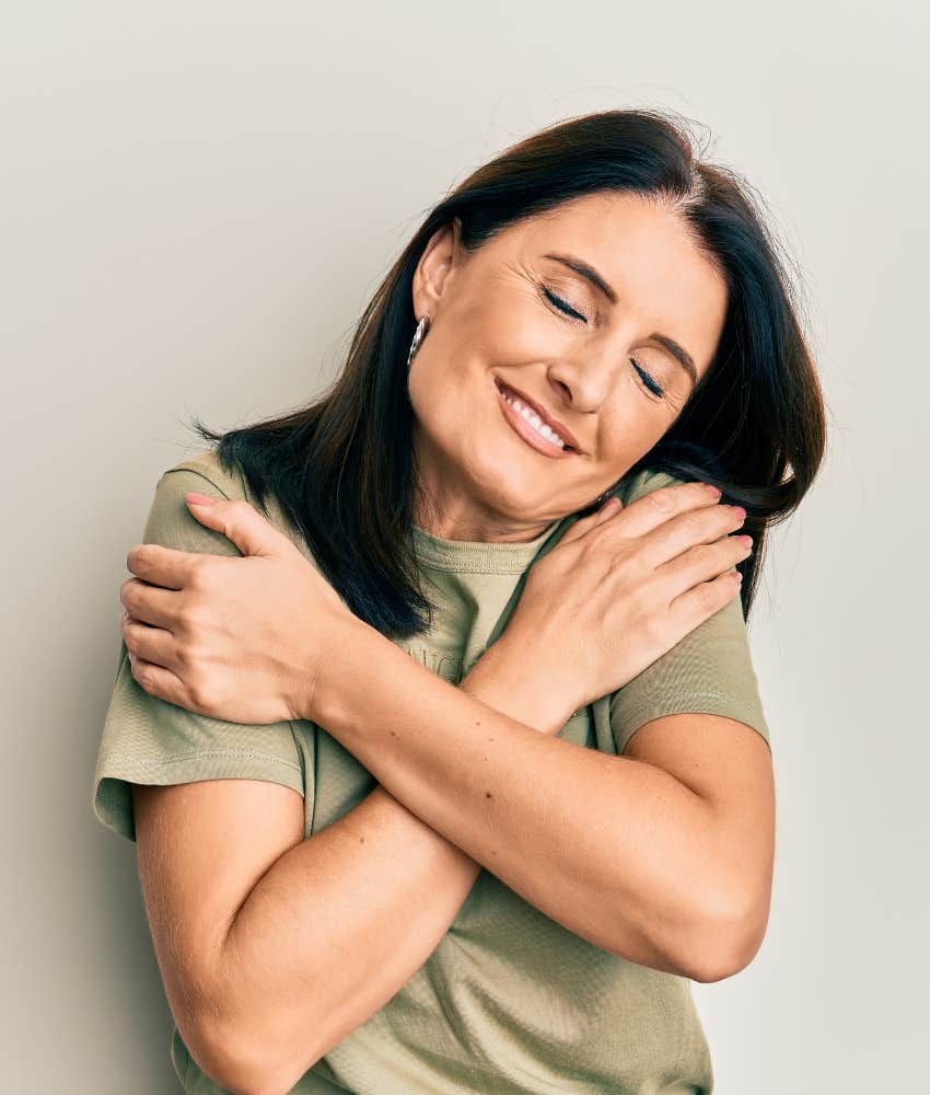 Happy person hugs self showing fulfillment of needs