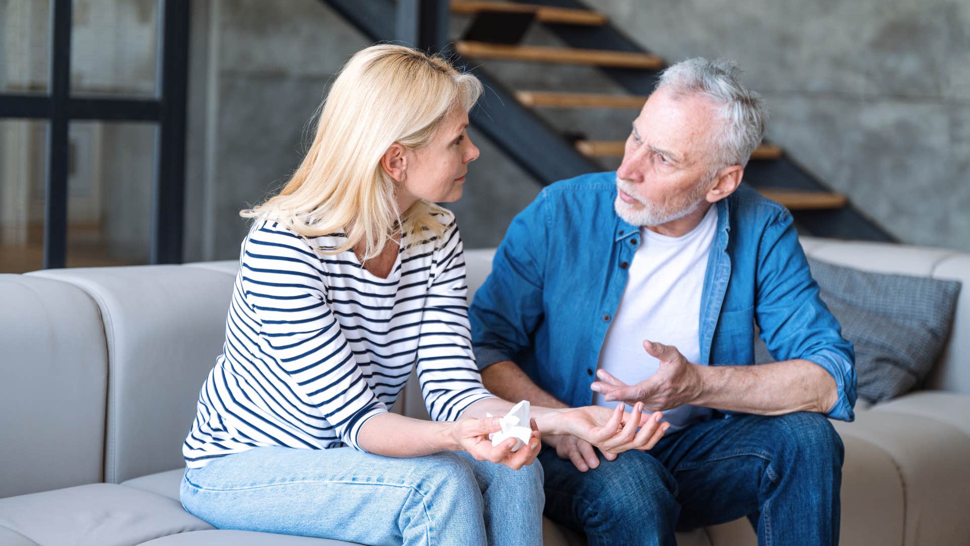 old couple talking on the couch husband saying i don't want there to be tension between us