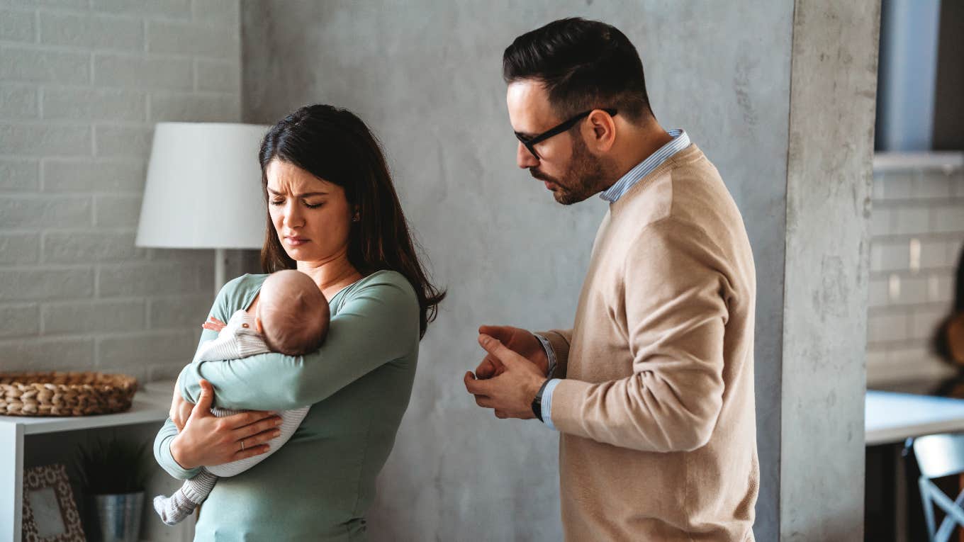 husband trying to comfort upset mom with newborn baby