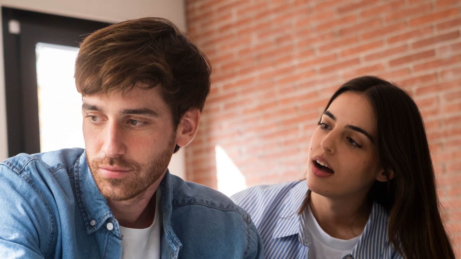 woman trying to comfort husband who is giving one-word responses