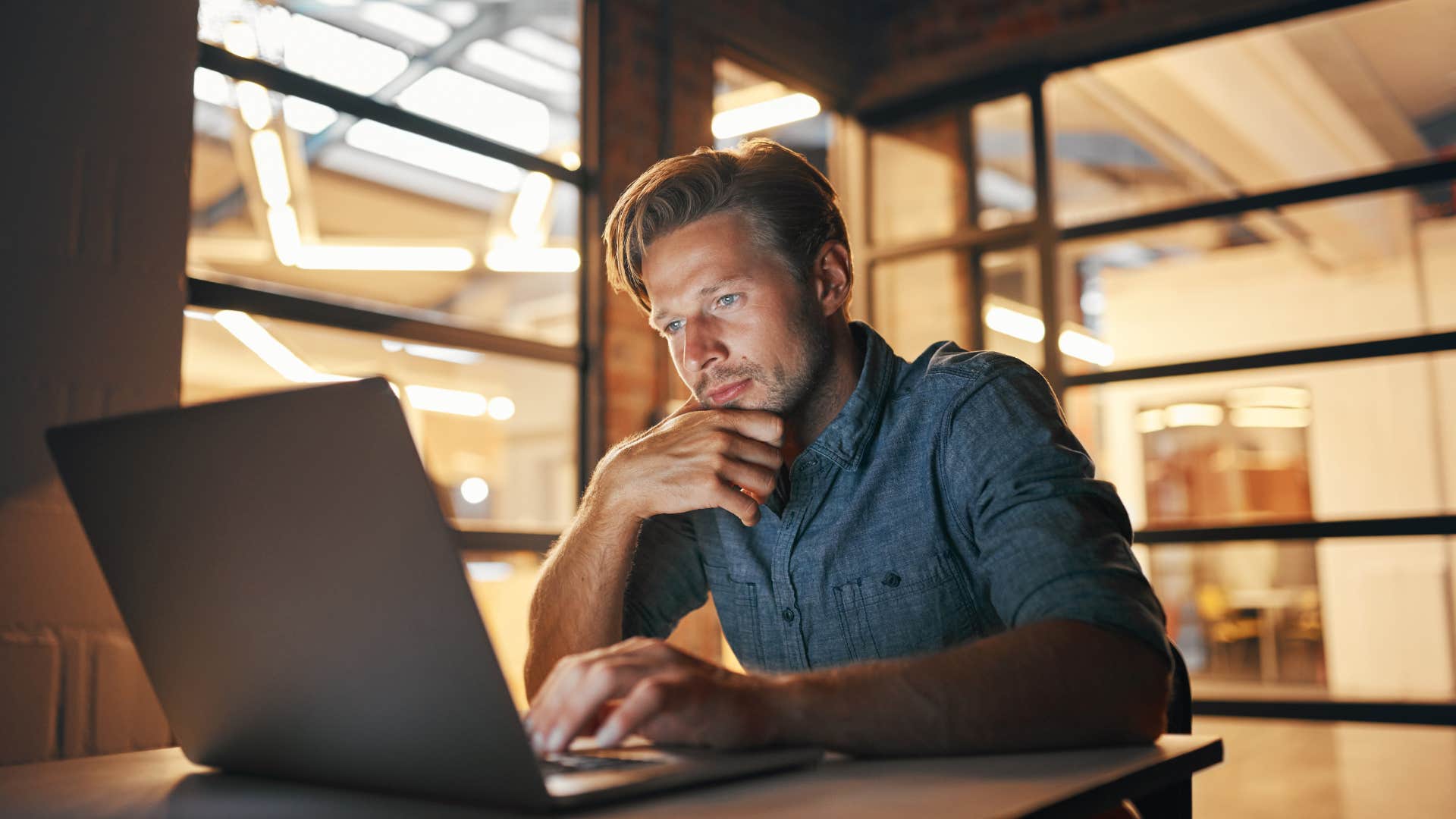 man on laptop working late to avoid wife