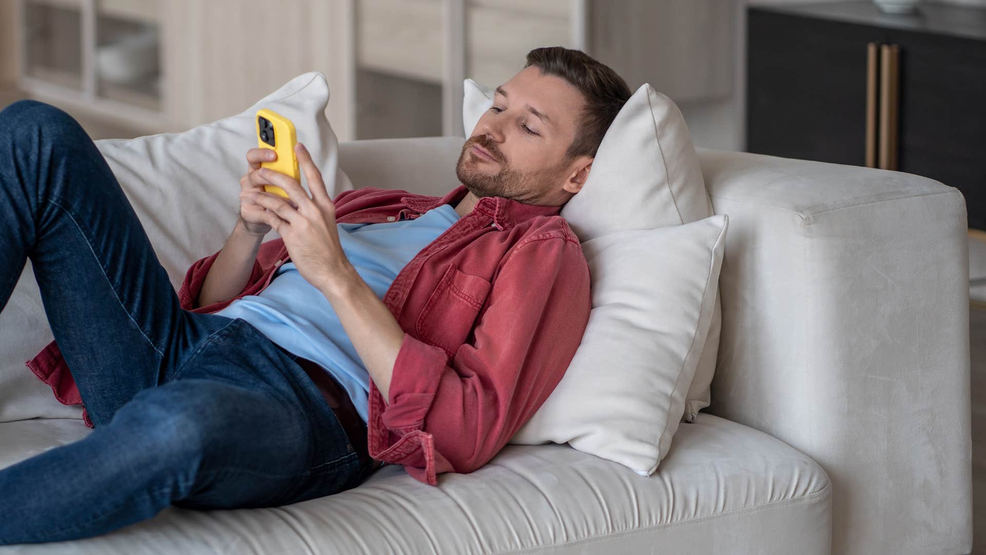 lazy man on phone putting less effort into his relationship