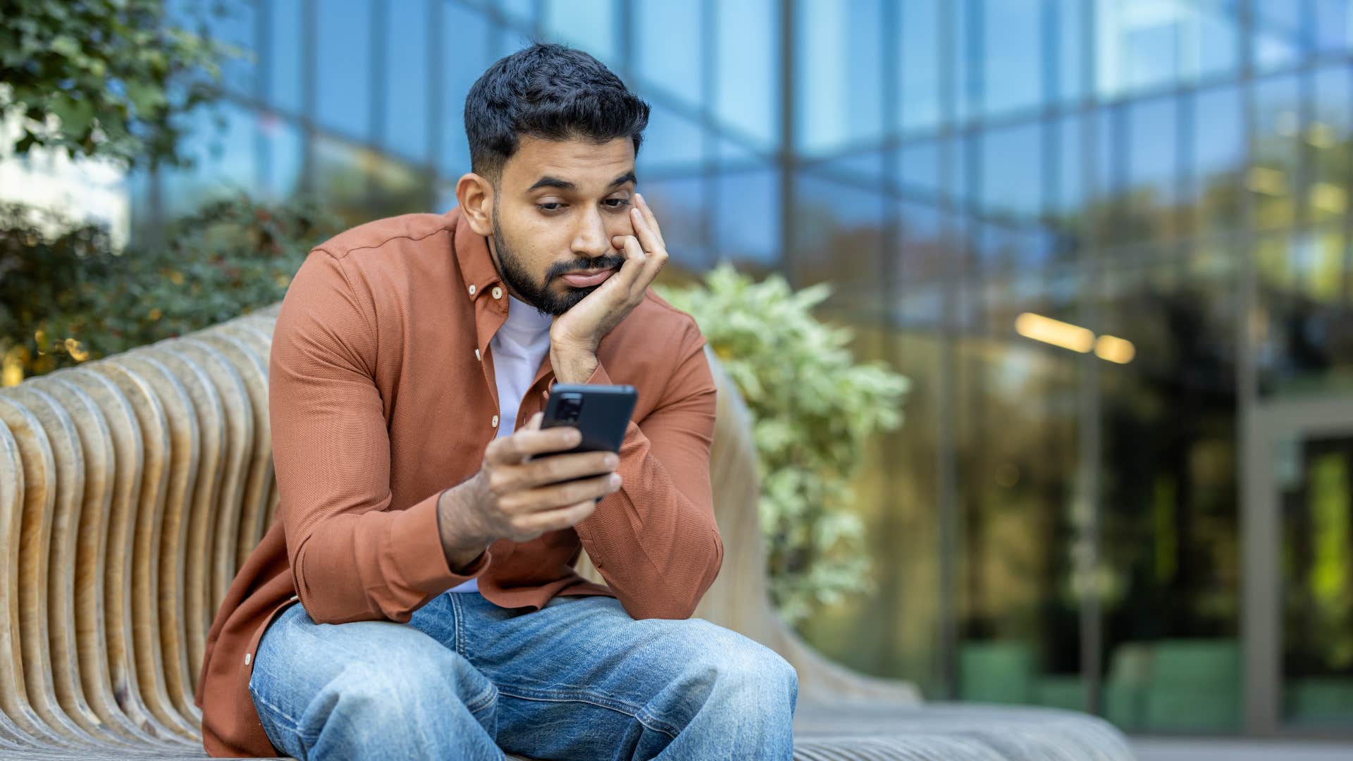 man on phone looking bored not making plans
