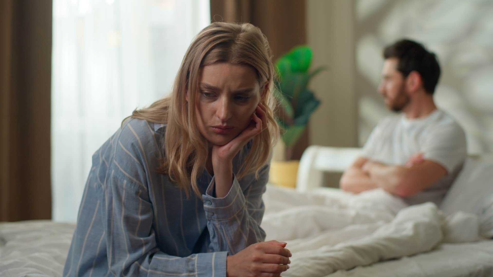 woman looking upset as man stops initiating conversation and ignores her