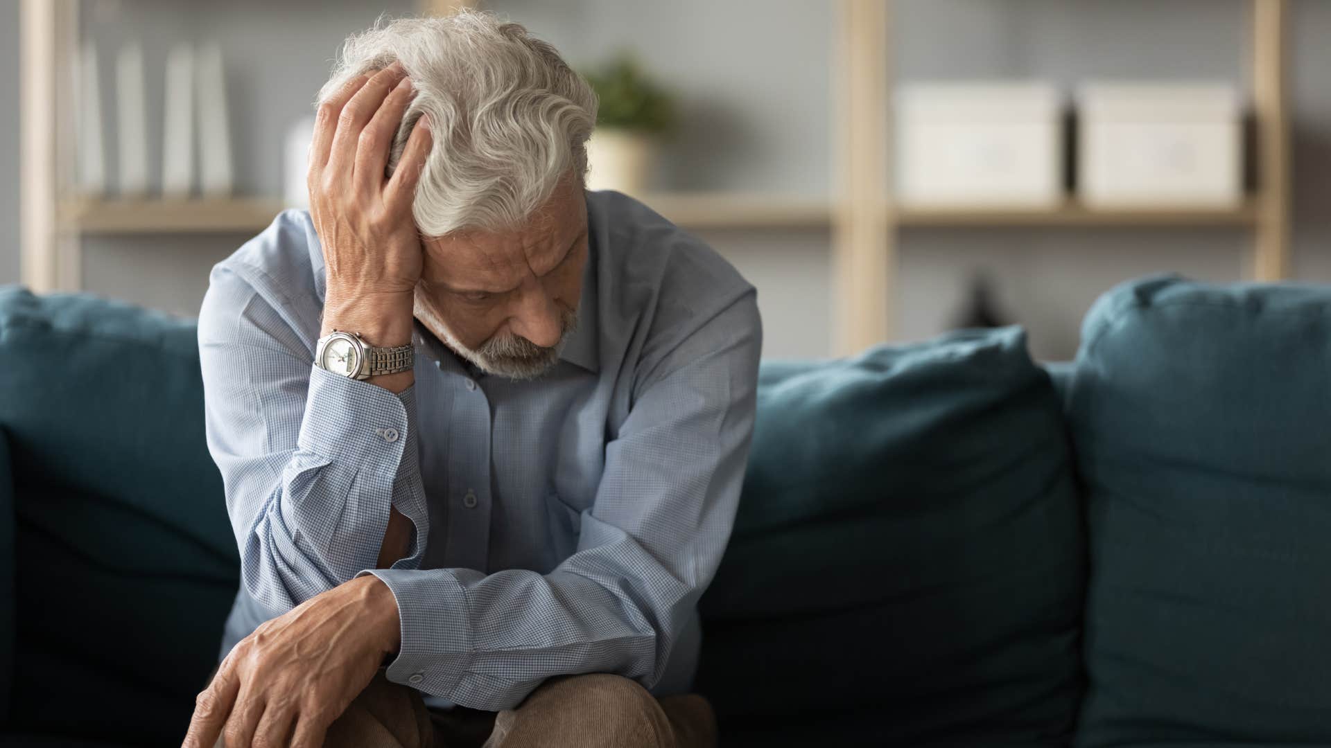 man sitting on couch saying he's tired