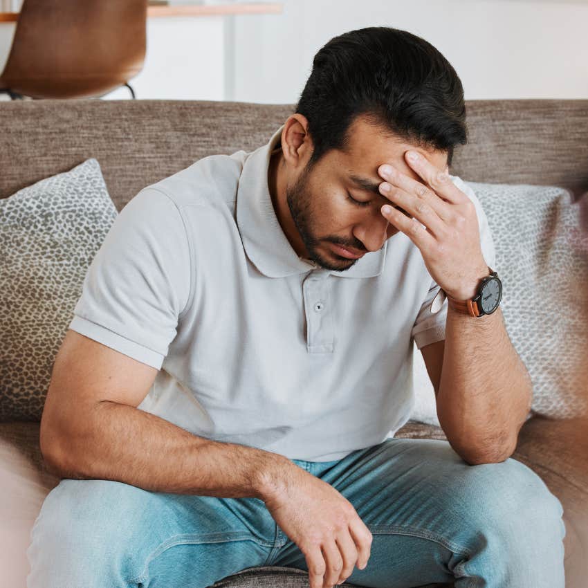 stressed man saying I'm just tired while holding his head