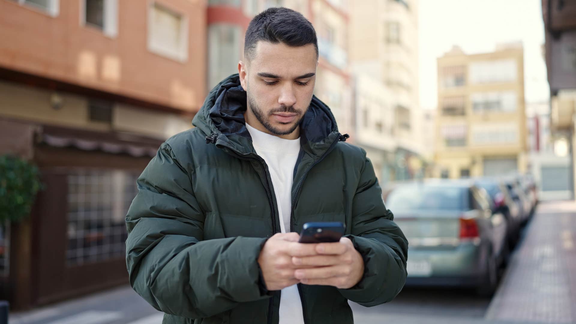 serious man texting while outside